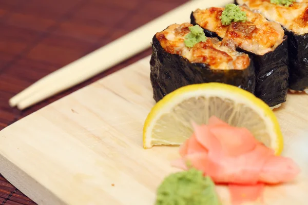 Stock image Sushi and rolls on the wooden plate