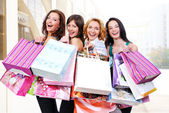 Glücklich lächelnde Frauen mit Einkaufstüten