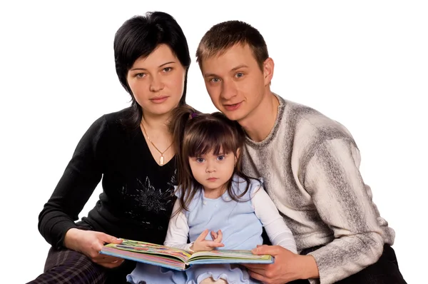 Família feliz lendo um livro — Fotografia de Stock