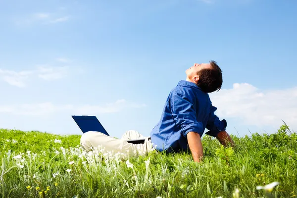 Liberdade - Homem trabalhando com laptop em um prado de flores com copyspace — Fotografia de Stock