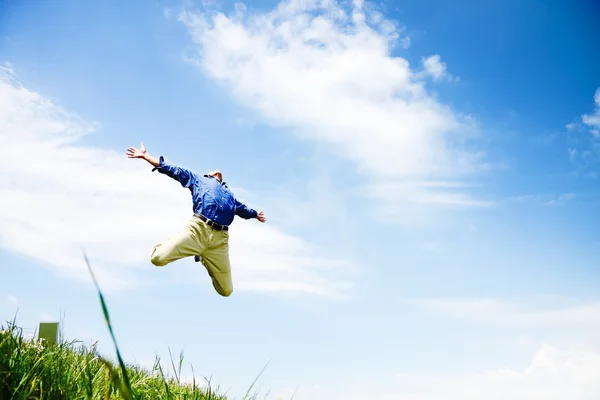 Свобода - Бизнесмен прыгает по зеленому лугу с копирайтом — стоковое фото