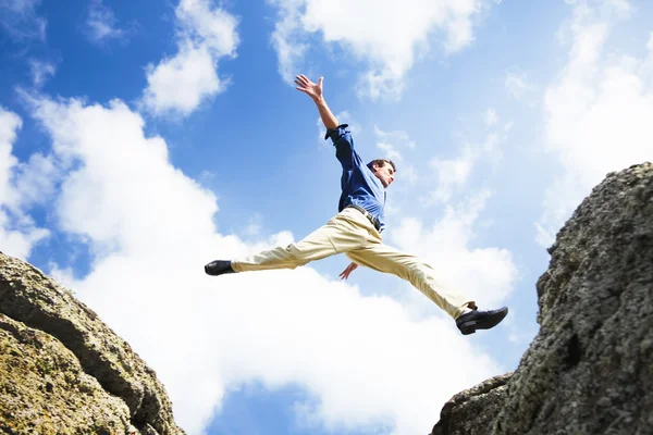 Бизнесмен прыгает через горы, бизнес-концепция — стоковое фото