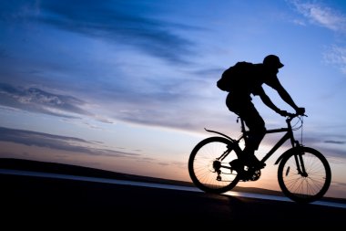 Silhouette of cyclists in motion clipart