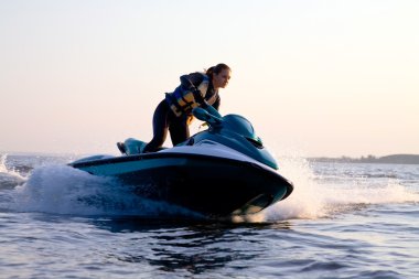 Beautiful girl riding her jet skis clipart