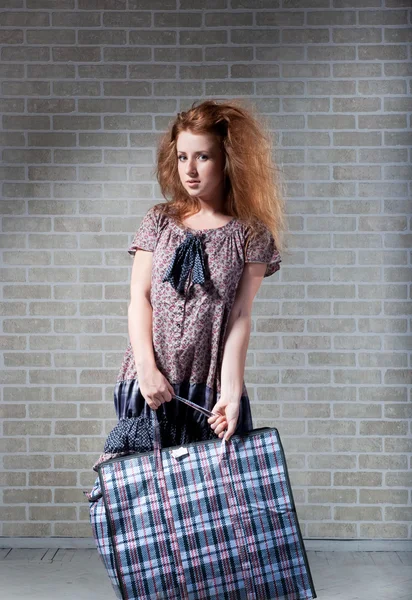 Trött rödhårig kvinna med shopping väska. — Stockfoto