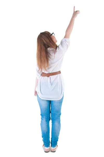 Young woman points at wall. — Stock Photo, Image