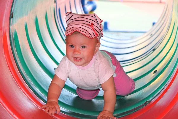 Happy baby in colorful pipe — Stock Photo, Image