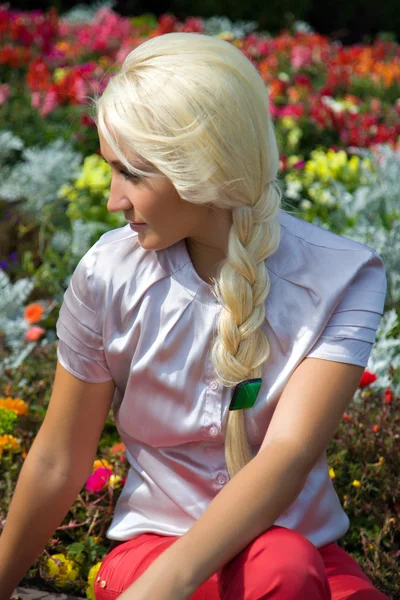 Blond tjej i blomma — Stockfoto