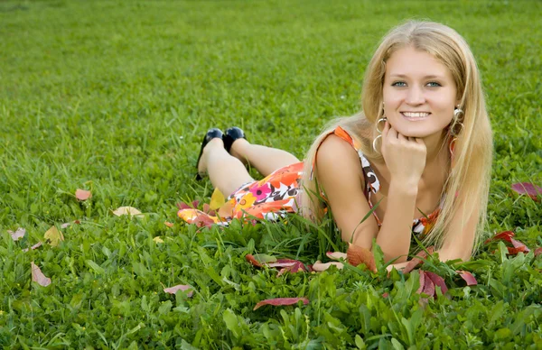Mujer joven acostada sobre una hierba verde — Foto de Stock