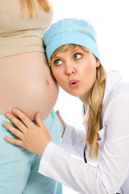 Doktor hamile kadın ele alıyor.