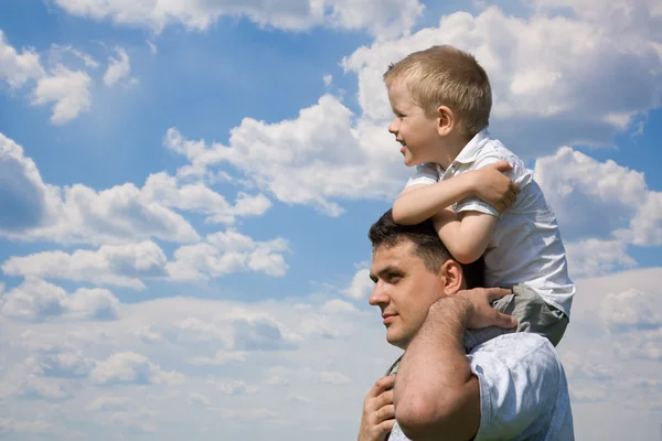 Synek siedzi na ramionach ojca — Zdjęcie stockowe