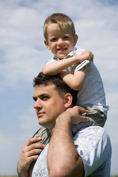Little son sits on father`s shoulders — Stock Photo, Image