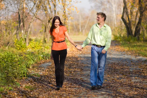 Young happy couple walking in the park — Stock Photo, Image