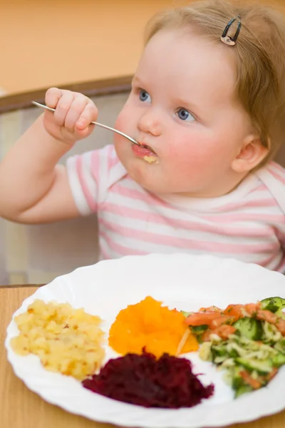 Ребенок ест овощной салат — стоковое фото