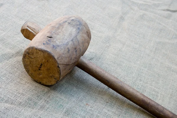 stock image Old wooden mallet hammer on burlap background