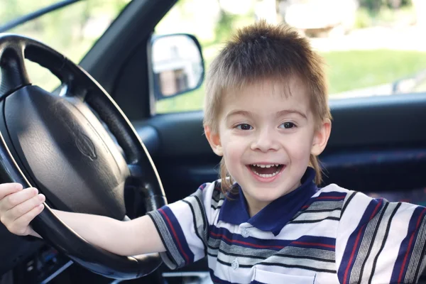 Boy after the helm of car — Stock Photo, Image