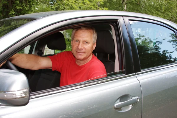 En äldre man är i en bil — Stockfoto