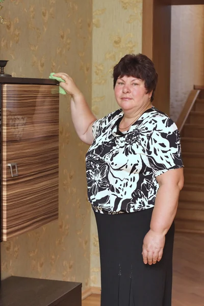 Una anciana se dedica a limpiar una casa —  Fotos de Stock