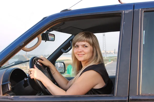 Girl after the helm of car — Stock Photo, Image