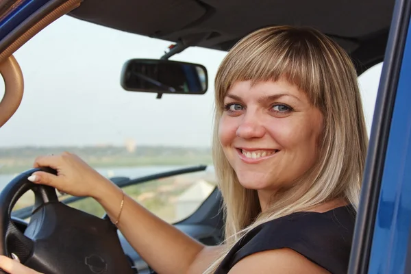 Girl after the helm of car — Stock Photo, Image