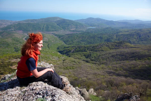 Женщина сидит на скале — стоковое фото