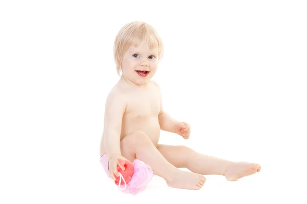 Sorrindo bebê menina está sentado e segurando uma esponja para tomar banho — Fotografia de Stock