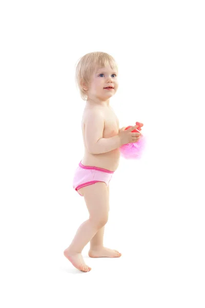 Souriant bébé fille debout et tenant une éponge pour se baigner — Photo