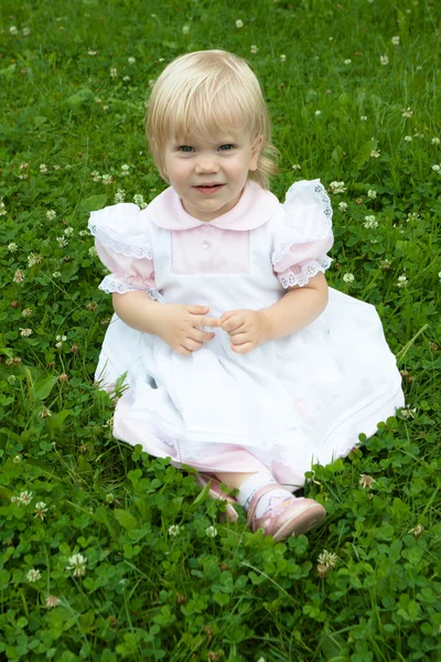 Jeune belle petite fille pose sur une herbe — Photo