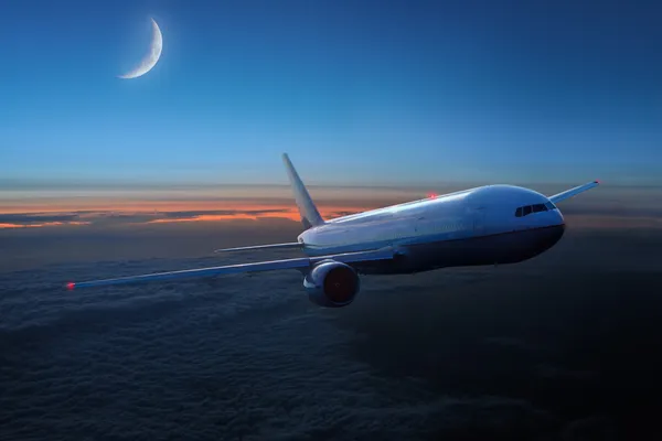 Geceleri gökyüzünde bir uçak — Stok fotoğraf