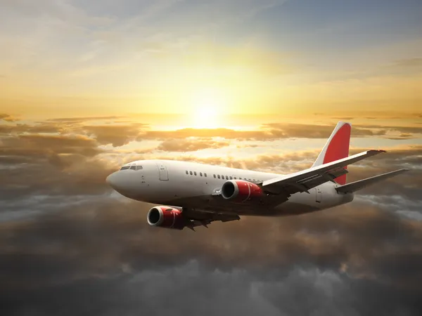 Airplane in the sky at sunset — Stock Photo, Image