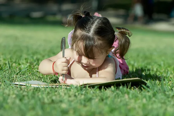 Küçük kız parkta çizim — Stok fotoğraf