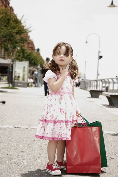 Kleines Mädchen mit Einkaufstaschen — Stockfoto