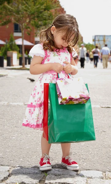 Маленькая девочка с сумками — стоковое фото