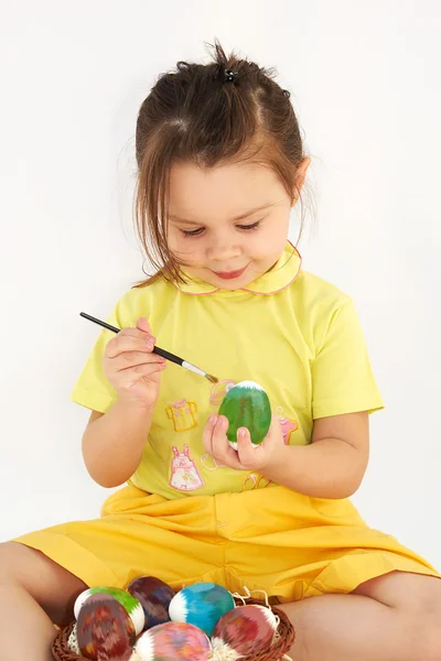 Девушка рисует пасхальное яйцо — стоковое фото