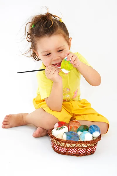 Девочка рисует пасхальное яйцо — стоковое фото