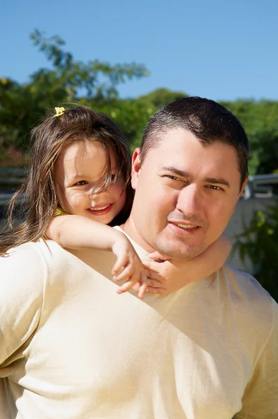Маленькая девочка обнимает своего отца в парке — стоковое фото