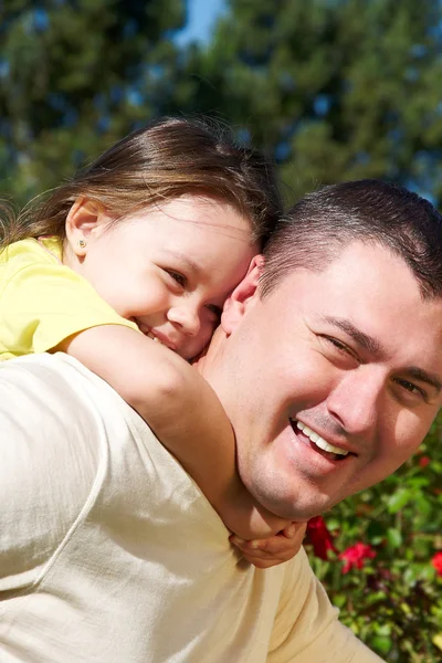 Klein meisje knuffelen van haar vader in het park — Stockfoto