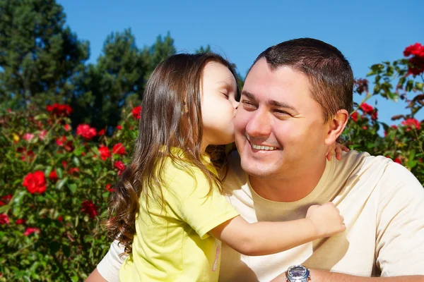 Kleines Mädchen umarmt ihren Vater im Park — Stockfoto