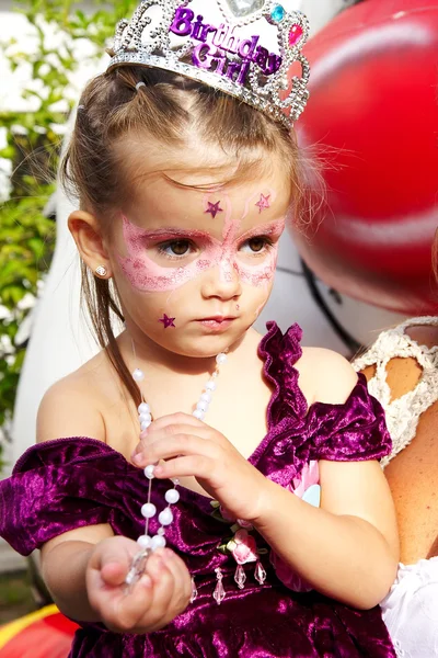 Beautiful little girl with painted face with paints — Stock Photo, Image