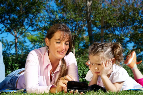 Mother and daughter lying in a park — Stock Photo, Image