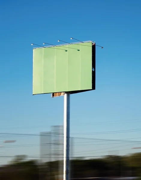 Large green poster near the road against the blue sky Stock Picture