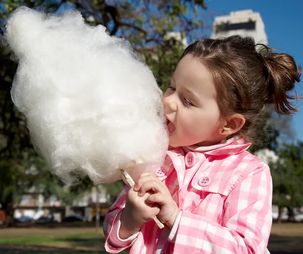 Girl eating candy-floss — Stock Photo, Image