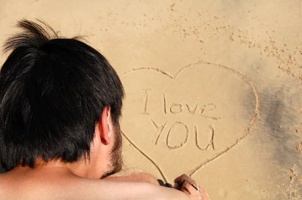 Homem escreve na areia Fotografias De Stock Royalty-Free