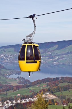 Cable car over alpine lake clipart