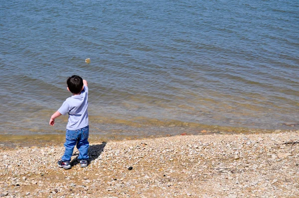 Chłopiec pomijam kamień po lewej stronie — Zdjęcie stockowe