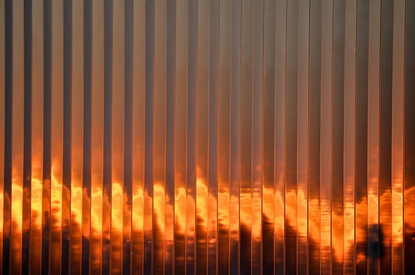 Pôr do sol flamejante contra o lado de um edifício — Fotografia de Stock