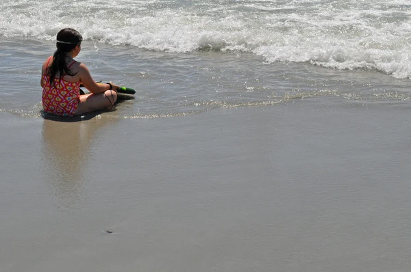 Liten flicka väntar på att surfa i havet — Stockfoto