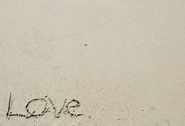 Amor escrito na areia canto inferior esquerdo — Fotografia de Stock