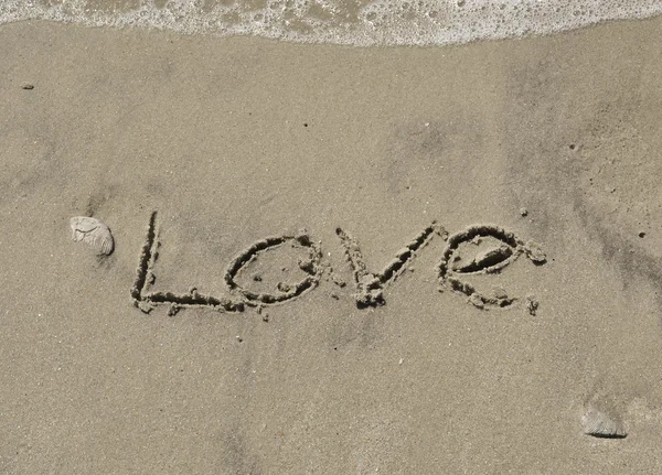 Любовь, написанная на песке с 17-й волной — стоковое фото