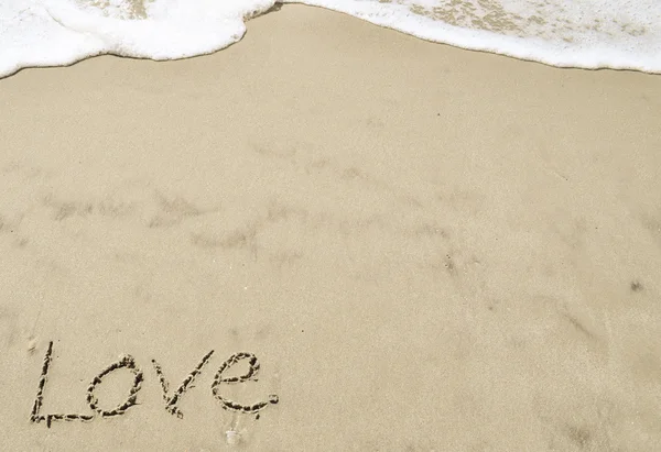 Amor escrito na areia com onda 24 — Fotografia de Stock